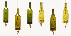 five wine bottles hanging from strings in the shape of corks