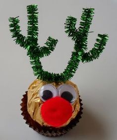 a cupcake with a reindeer face on it and some green branches sticking out of the top