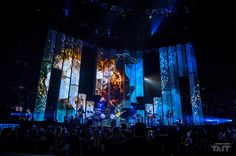 the stage is lit up with colorful lights and people are standing in front of it