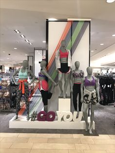 several mannequins are standing in front of a display window with the word go written on it