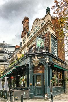 an old building with a clock on the top of it's roof and balcony