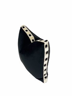 a black and white bag with polka dots on the side, sitting in front of a white background