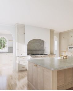 a large kitchen with an island in the middle and two ovens on each side