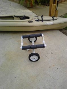 a kayak is parked next to a cart with wheels