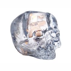 a crystal skull candle holder is shown on a white background with the light shining through it