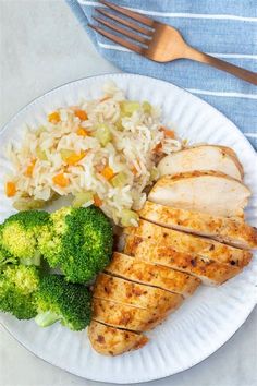 a white plate topped with chicken, rice and broccoli next to a fork