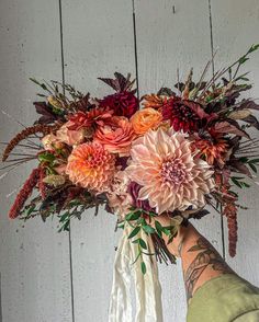 a person holding a bouquet of flowers in their hand