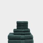 a stack of green towels sitting on top of a white floor next to a wall