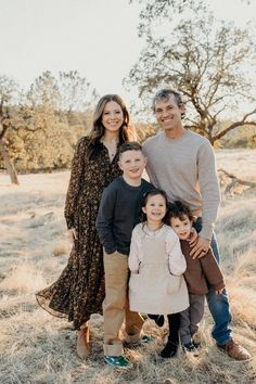 a family poses for a photo in an open field