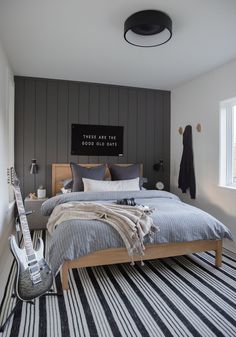 a bed room with a neatly made bed and a guitar