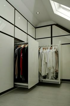 an open closet with clothes hanging on hangers