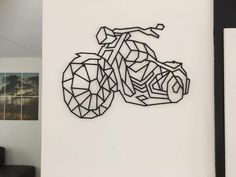 a black and white drawing of a motorcycle on the wall next to a couch in a living room