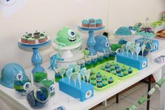 a table topped with cupcakes and cakes covered in blue frosted icing