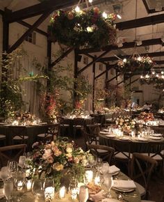 the tables are set with candles, flowers and greenery for an elegant wedding reception