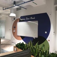 an office with plants in the foreground and a sign that says express our mood