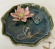 a green plate with a flower and chain on it