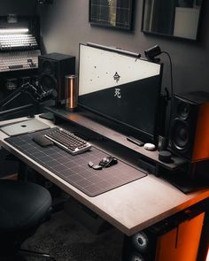 a computer desk with a keyboard, mouse and speakers on it in a home studio