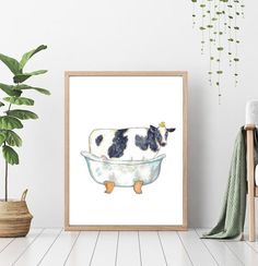 a cow is sitting in a bathtub with watercolors on the wall next to it