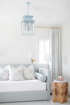 a living room with a couch, table and lamp hanging from it's ceiling