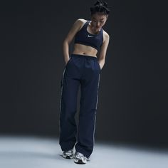 Reaching back to our roots, these easy-fitting pants pull inspiration from the Nike looks of the '70s. A water-repellent finish and UV technology built into the crinkle-woven fabric help keep you good to go come rain or shine. Nike Pants For Women, Nike Athletes, Nike Windrunner, Nike Looks, Nike Track Pants, How To Hem Pants, Rain Or Shine, Women Lifestyle, Blue Nike