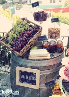 an assortment of grapes and cheeses on display in a barrel