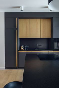 a kitchen with black counter tops and wooden cabinetry on the wall, along with an island