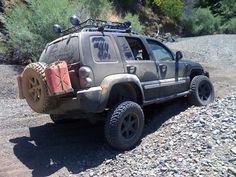 an off road vehicle parked on the side of a dirt road