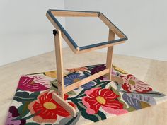 a wooden frame sitting on top of a colorful rug