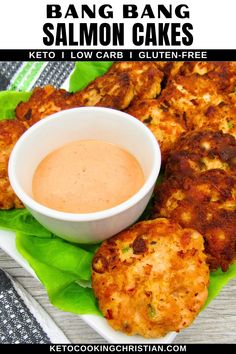 a plate with some crab cakes and a bowl of dipping sauce on the side next to it