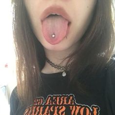 a woman sticking her tongue out and wearing a black shirt