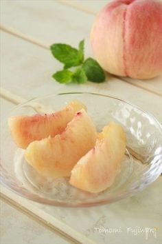 two pieces of peach sitting on top of a glass plate