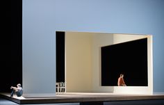 two figurines sitting on top of a table in front of a black and white wall