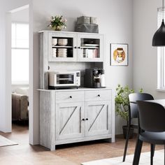 a kitchen area with a microwave, cabinets and dining room table in the foreground