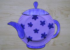 a paper plate shaped like a teapot with blue flowers on the outside and inside