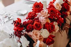 red and white flowers are arranged on the table for a wedding reception or special event