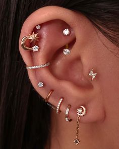 a woman wearing multiple ear piercings with stars and moon designs