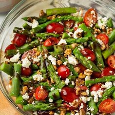 a salad with tomatoes, cucumbers and feta cheese on top is served in a white bowl