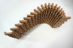 a sculpture made out of wooden sticks on a white surface with one section cut open