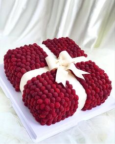 a red and white cake with a bow on top