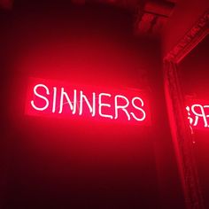 a red neon sign that says sinners on it