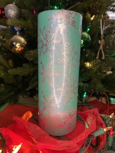 a lit candle sitting in front of a christmas tree