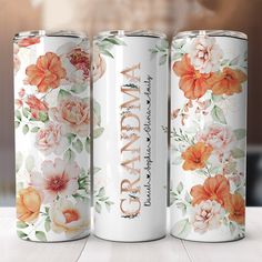 three white cans with orange and pink flowers on them