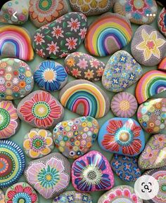 many colorful rocks are arranged together on the ground and one is painted with different colors