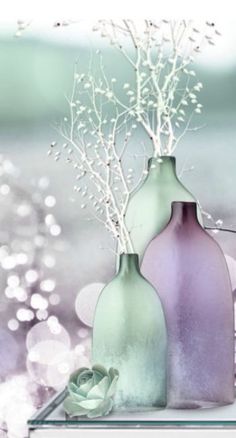 two vases with flowers in them sitting on a table