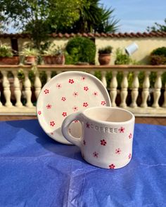 a coffee cup and saucer sitting on top of a blue table cloth