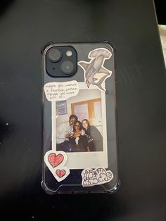 a cell phone case with an image of two people and heart stickers on it