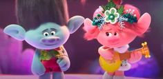 two cartoon characters standing next to each other in front of a purple background with flowers on their head