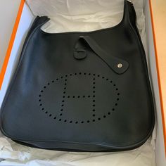 This Is An Authentic Hermes Evelyne Bag Size 40 In Never Worn Condition. The Size Is Amazing For Everyday Use And Can Carry A Laptop Or Ipad In Addition To Other Items. Comes With A Cross Body Strap (Or Shoulder If You Shorten It). Hardware Is Palladium. Great For Traveling Too. Comes With The Original Box And Dust Bag. Bought At Hermes / Bev Hills - July 2022. *Please Note That Due To How It Was Stored, There Are Identical Tiny White Lines In The Opposite Corners. They Are Barely Detectable. Pl Birkin Bag Price, Hermes Travel Bag, Hermes Evelyne Iii, Hermes Evelyn Bag, Hermes Kelly 28, Hermes Kelly Bag, Kelly Bag, Canvas Crossbody Bag, Black Leather Crossbody Bag