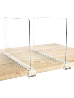 two clear acrylic shelves sitting on top of a wooden table