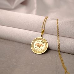 a close up of a gold necklace on a white cloth